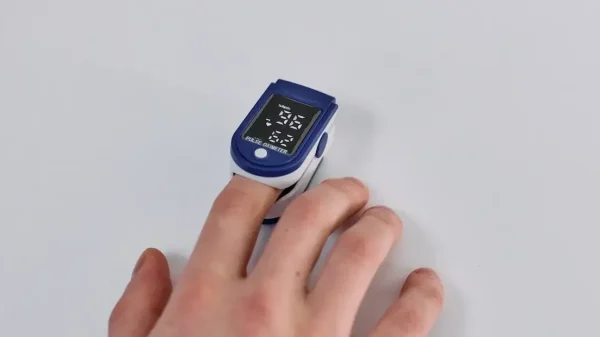 Saturatiemeter aan een hand voor het artikel hoe werkt een saturatiemeter.
